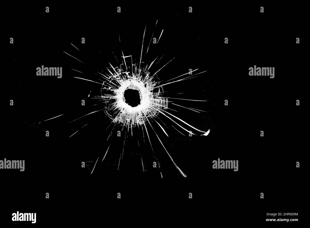Texture of broken glass. Hole from a ball on a black background. Stock Photo