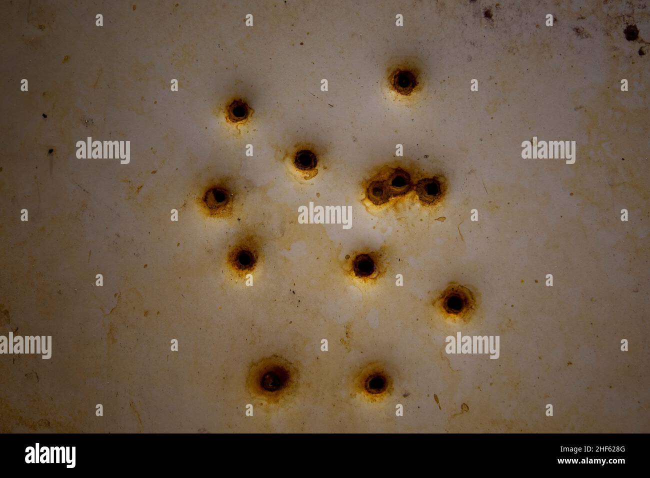 Rusty bullet holes in a metal plate. Stock Photo