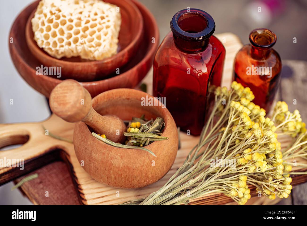 immortelle ,Curry Plant, Herb of St. John, Immortelle and botanically, Helichrysum arenarium dry herbs in a mortar. and honey in honeycombs. Ingredien Stock Photo