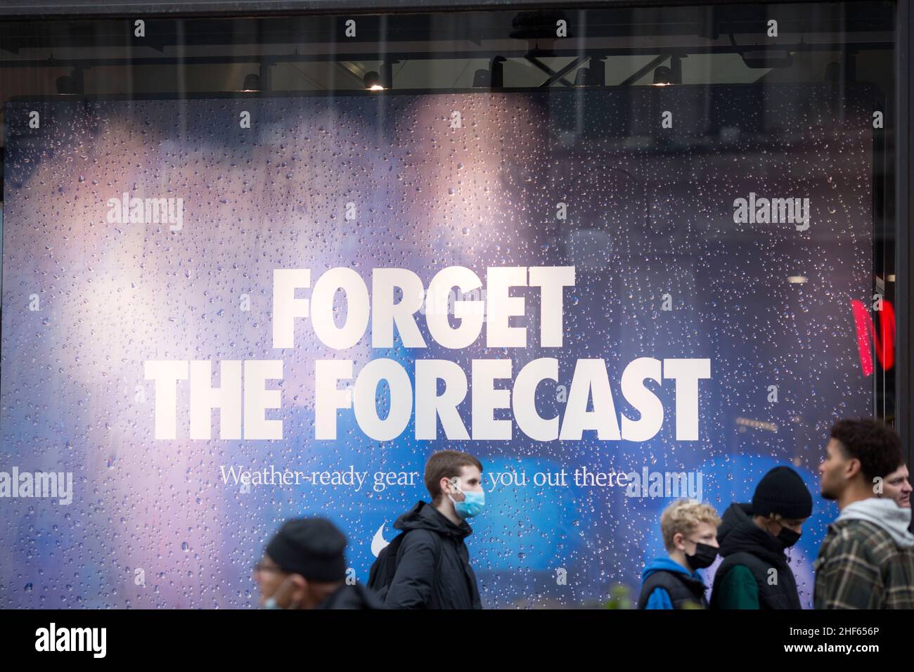 People queue in front of an advertisement reading 'Forget the Forecast'  outside a Nike Town store on Boxing Day in central London Stock Photo -  Alamy