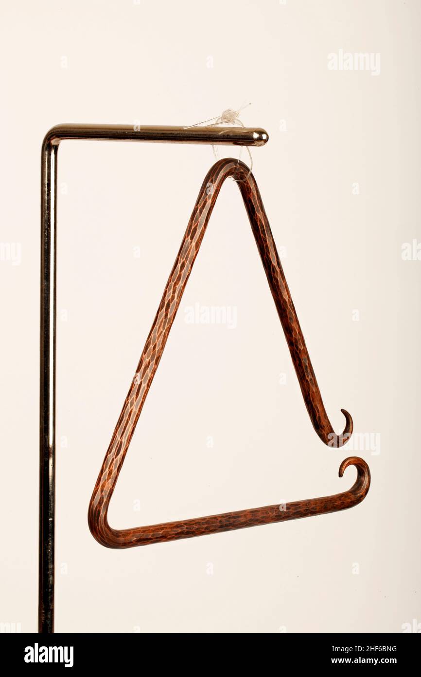 Hand hammered bronze triangle. Baroque, renaissance. Stock Photo