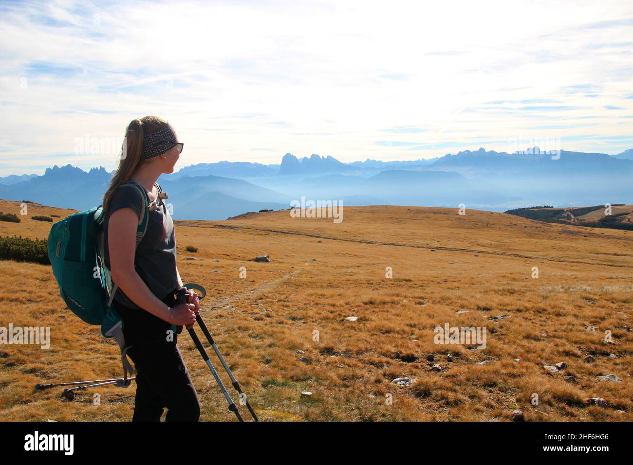 Young woman on a hike to the refuge and the Latzfonser Kreuz pilgrimage church. Latzfons,  Klausen,  Bolzano Province,  South Tyrol,  Italy,  Europe. Far left the Geislerspitzen 3025 m,  right next to the hiker the Sella group,  in the middle the Langkofel group,  right the Schlern with the Rosengartenspitze alpine panorama Stock Photo