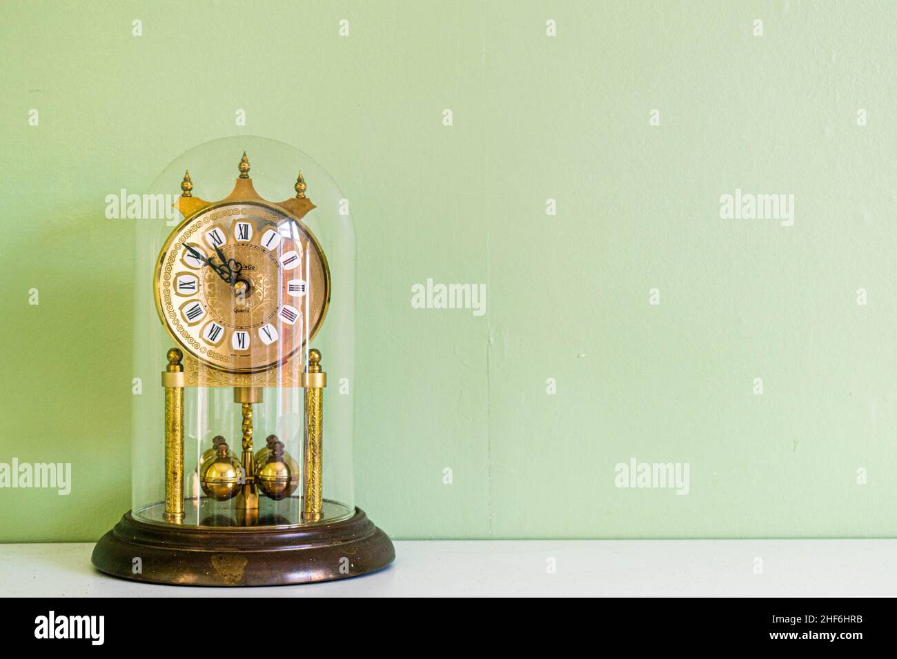 Hull, UK - 26th August 2019: Antique vintage gold bronze house clock with roman numerals and a ticking hand. Home lifestyle, home décor, lifestyle Stock Photo