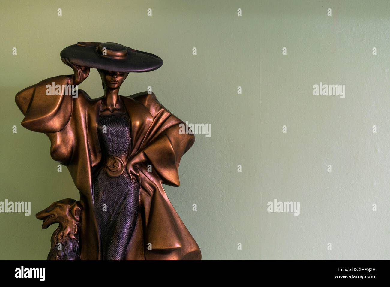 Hull, UK - 25th August 2019: Posh classy lady with large hat and dog home décor ornament. Unique bronze metal statue conceptualising modern vintage Stock Photo