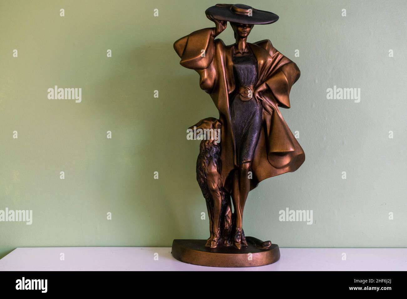 Hull, UK - 25th August 2019: Posh classy lady with large hat and dog home décor ornament. Unique bronze metal statue conceptualising modern vintage Stock Photo