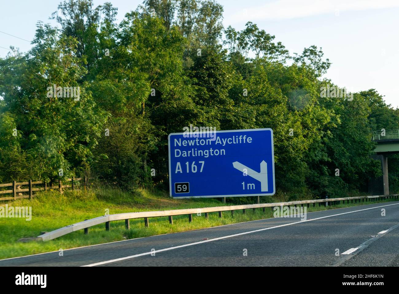 Blue road sign on a British, UK, motorway for junction 59 off the busy A1 freeway to Newton Aycliffe and Darlington. Copy space. Stock Photo