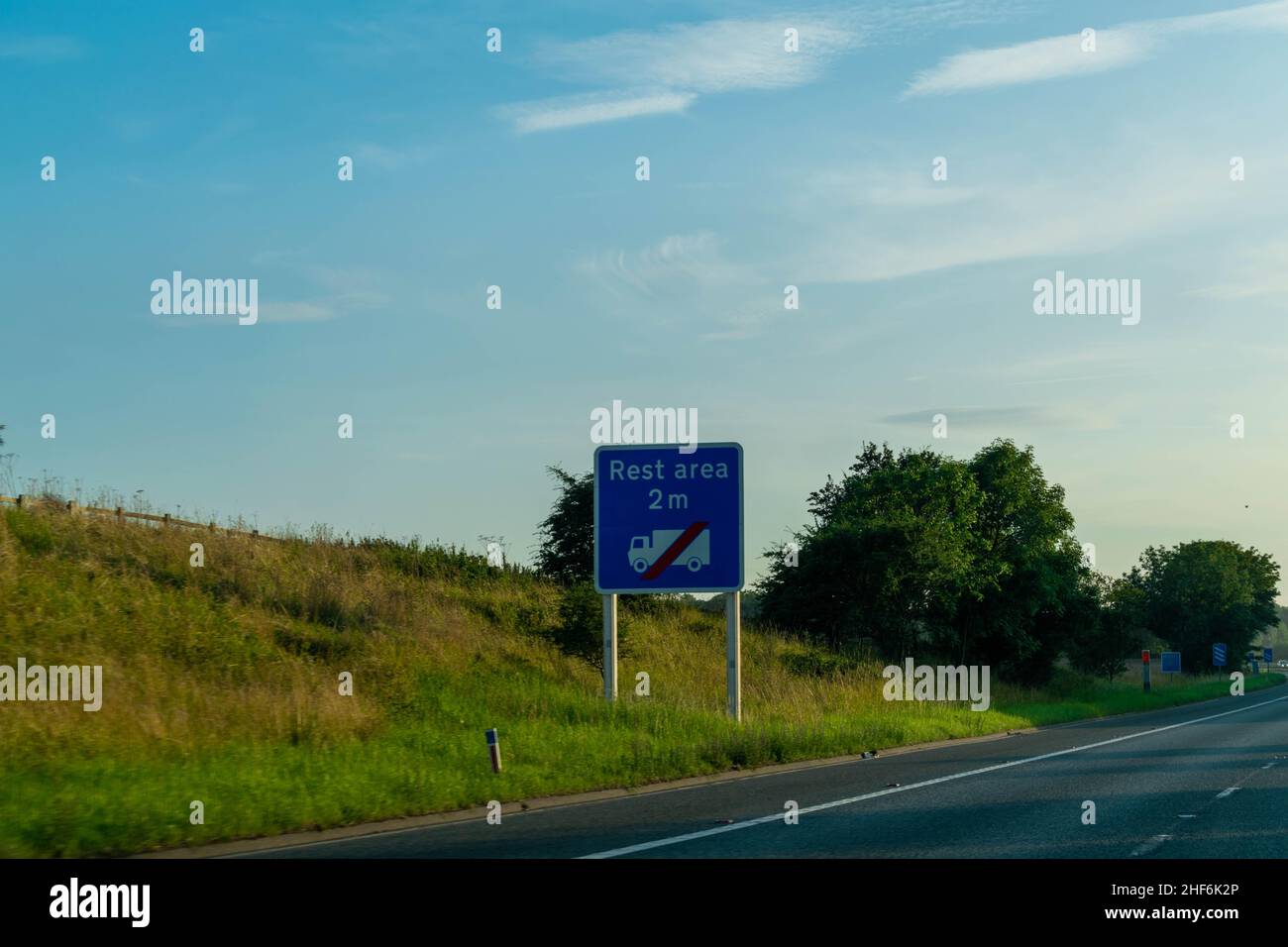 Bleu British motorway road sign advising drivers to pull over, stop and rest at the rest area to avoid tiredness whilst driving. Safety instruction Stock Photo
