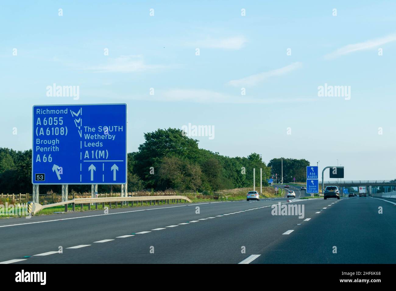 Leeds, UK - 23rd August 2019: Cars drive down the A1 British motorway with blue highway signs directing drivers to Richmond, Leeds, Brough, Wetherby, Stock Photo