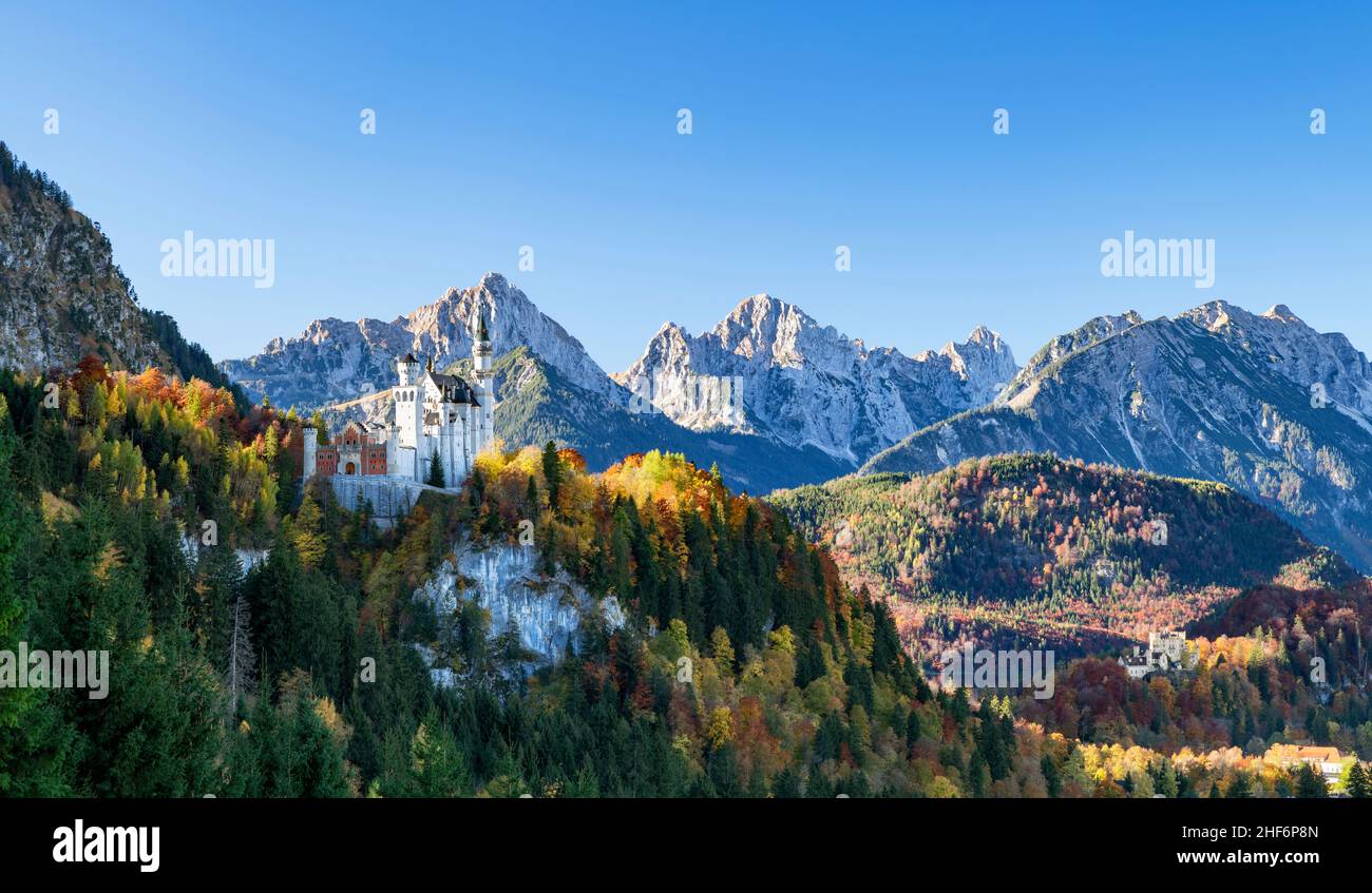 Neuschwanstein Castle in front of a wild mountain landscape on a sunny autumn day. Allgäu Alps,  Bavaria,  Germany,  Europe Stock Photo