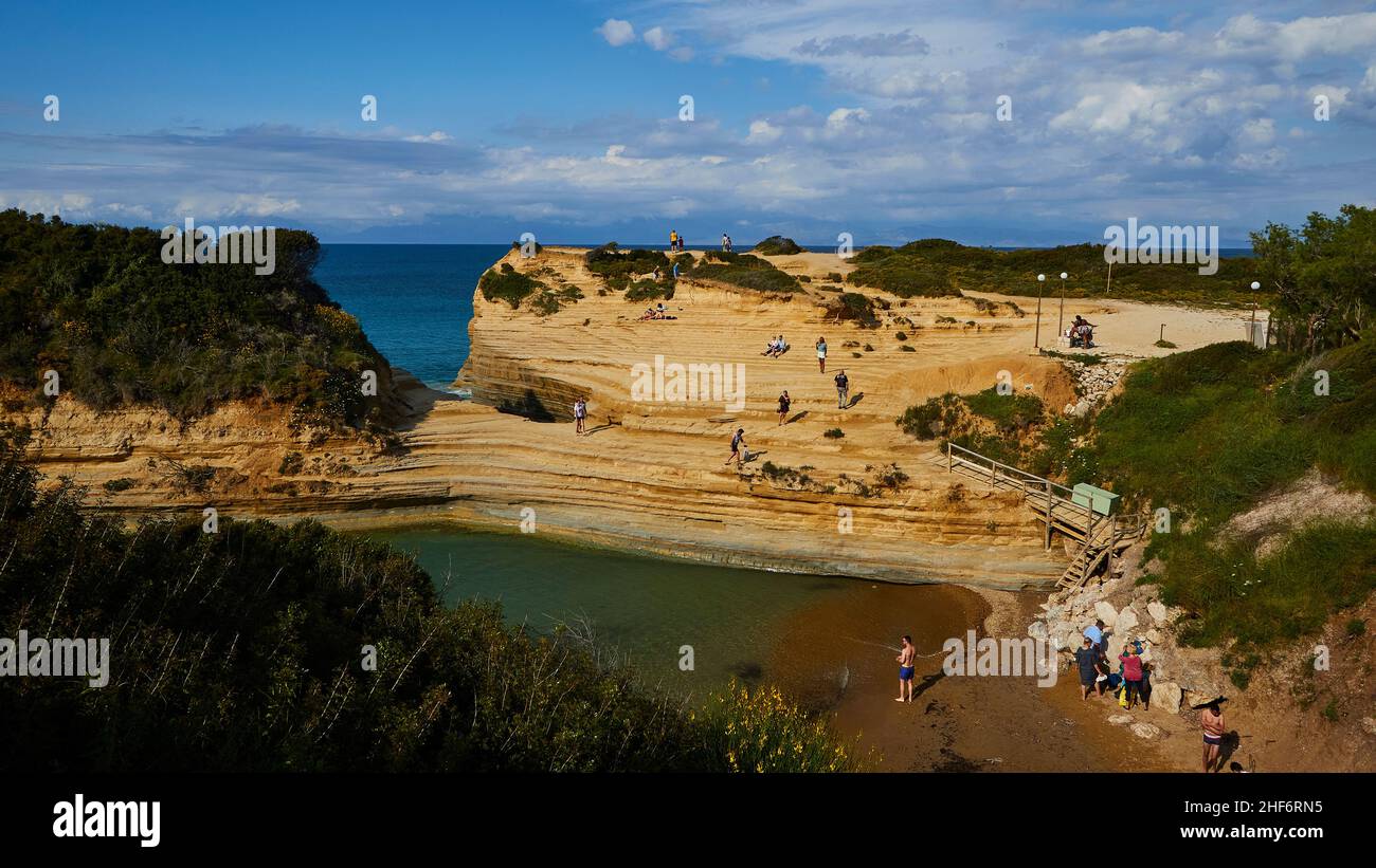 Greece,  Greek Islands,  Ionian Islands,  Corfu,  north coast,  bizarre rock formations on the coast,  Canal d'amour,  blue sky,  white clouds,  turquoise sea,  blue and green,  bay with people,  rocky coast Stock Photo