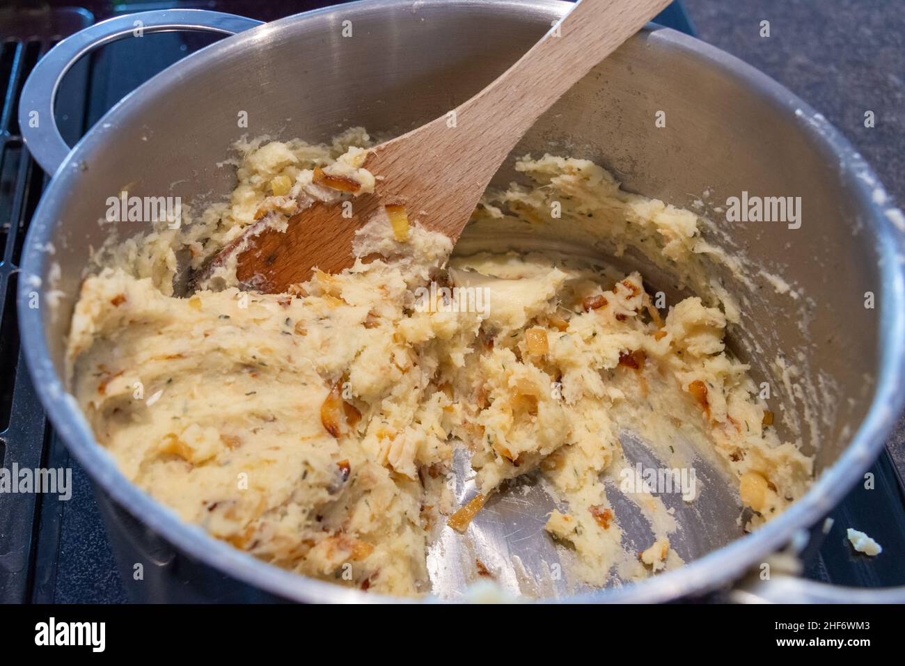 A pot of uncooked salt cod fishcakes is prepared for frying. The mixture of savory, potato, salt codfish, and butter is shaped into small patties. Stock Photo