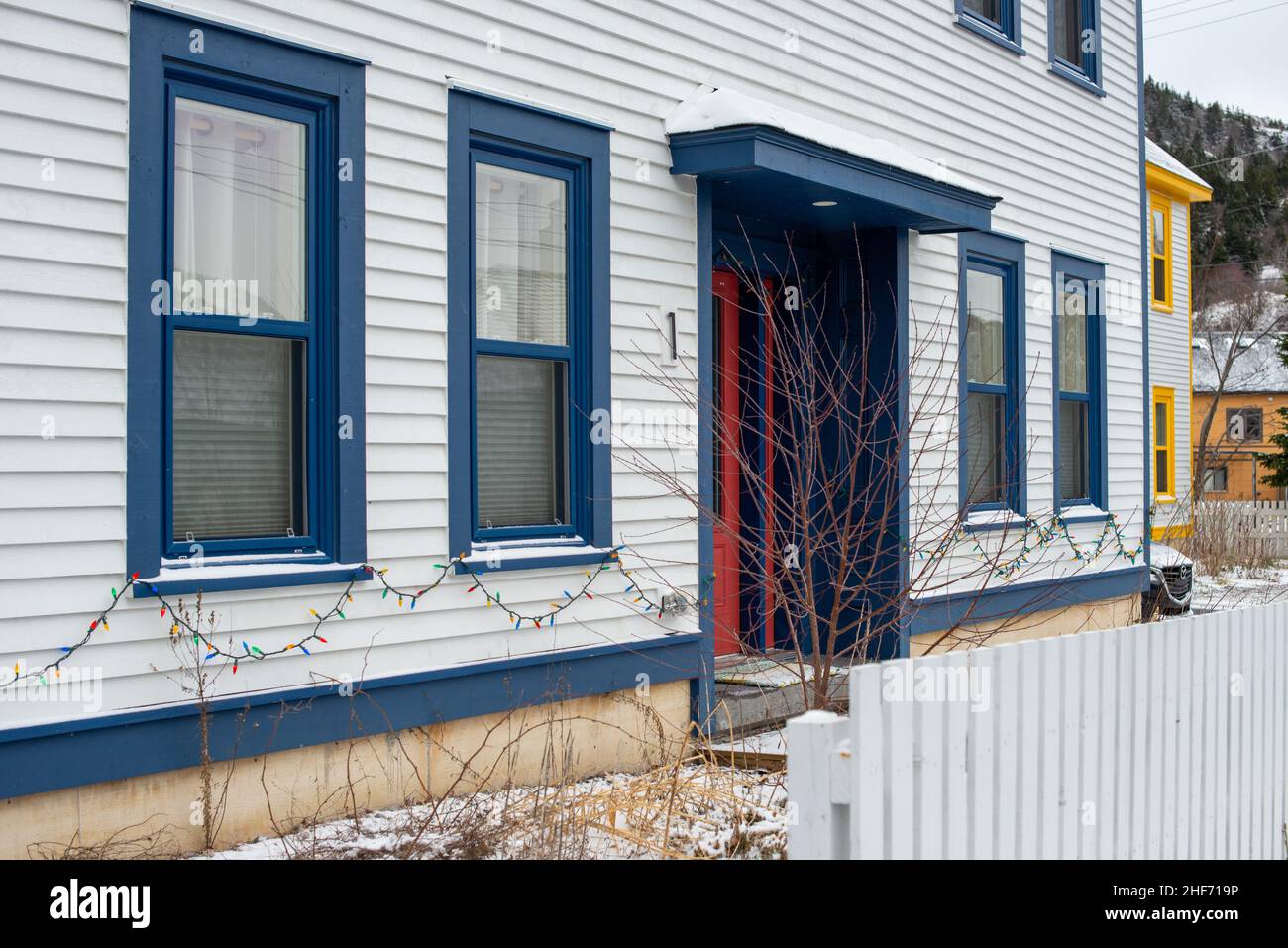 The exterior of a stark white cape cod clapboard horizontal wooden board siding wall with