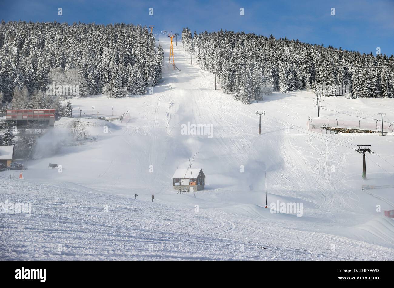 12 January 2022, Saxony, Oberwiesenthal: From numerous lances the slope at the Fichtelberg is covered with snow. On Saturday, 15.01.2022, this year's ski season will be officially ushered in at Fichtelberg. Due to Corona, the ski area is only open to those who have been vaccinated and recovered (2G), and a mask must be worn when queuing at the lift and in the lift itself. The 2G status is checked before purchasing the ski pass as well as in the ski resort. For this purpose, a control point and a central sales point for lift tickets will be set up in the parking lot of the Fichtelberg cable car Stock Photo