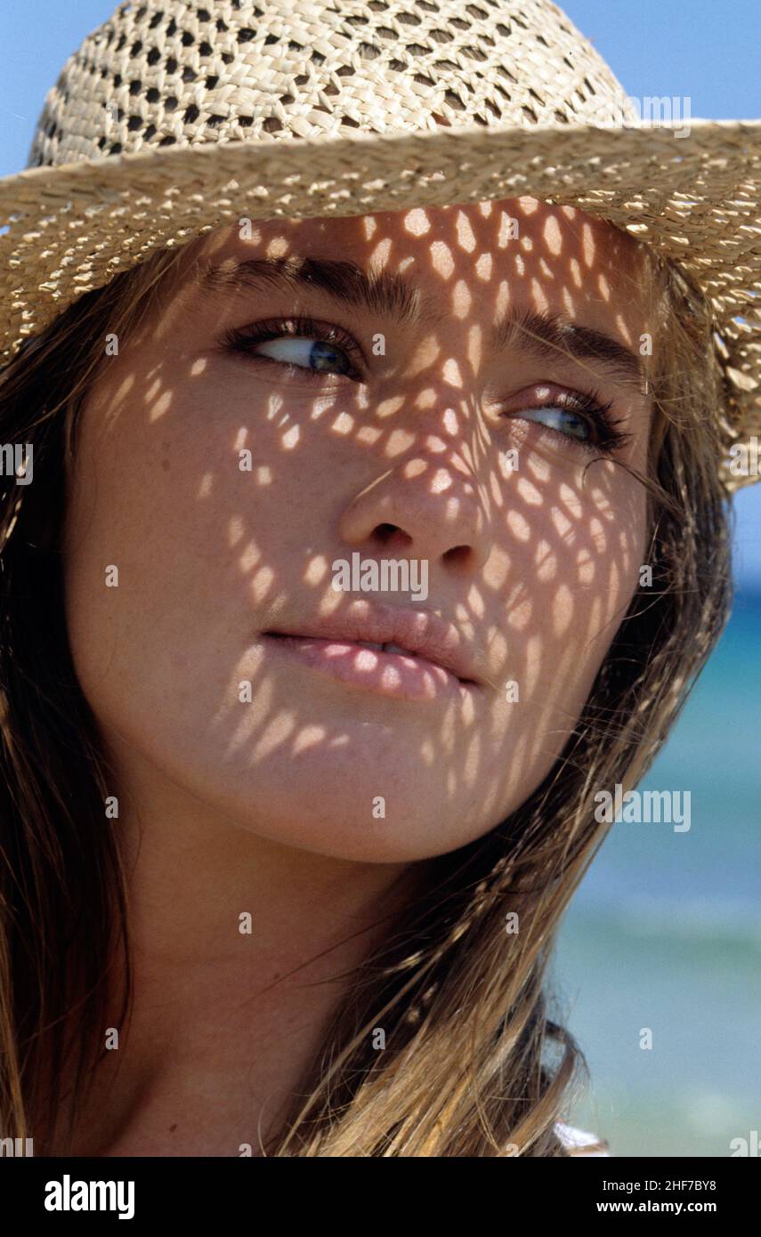 attractive blond hair young woman sunny portrait looking front camera  close up natural sweety face wilth straw hat blue sky on background Stock Photo