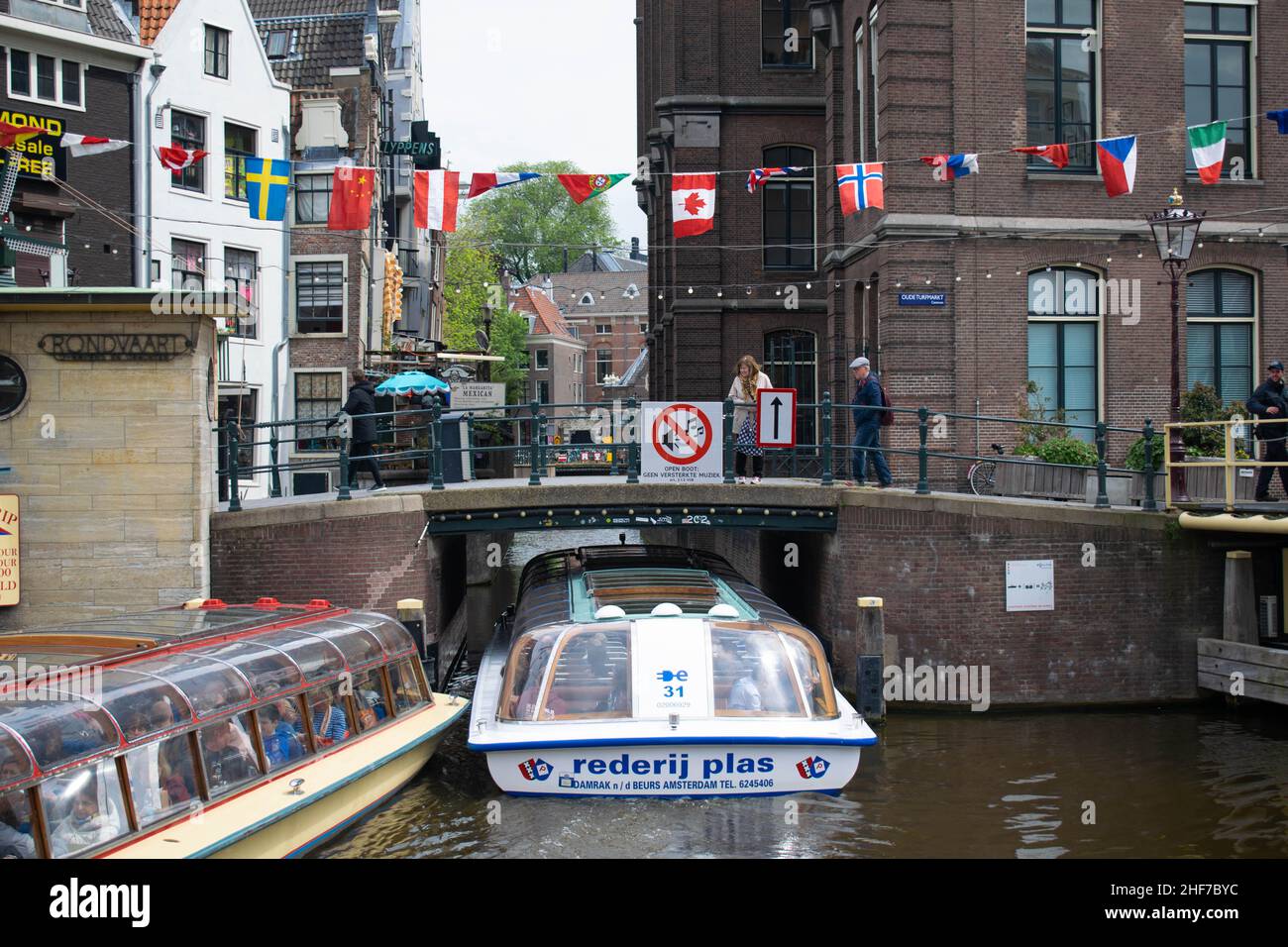 Amsterdam, Holland, The Netherlands - 6th May 2019: Numerous different nationality flags flying in the wind on the canal in Amsterdam on a summers day Stock Photo