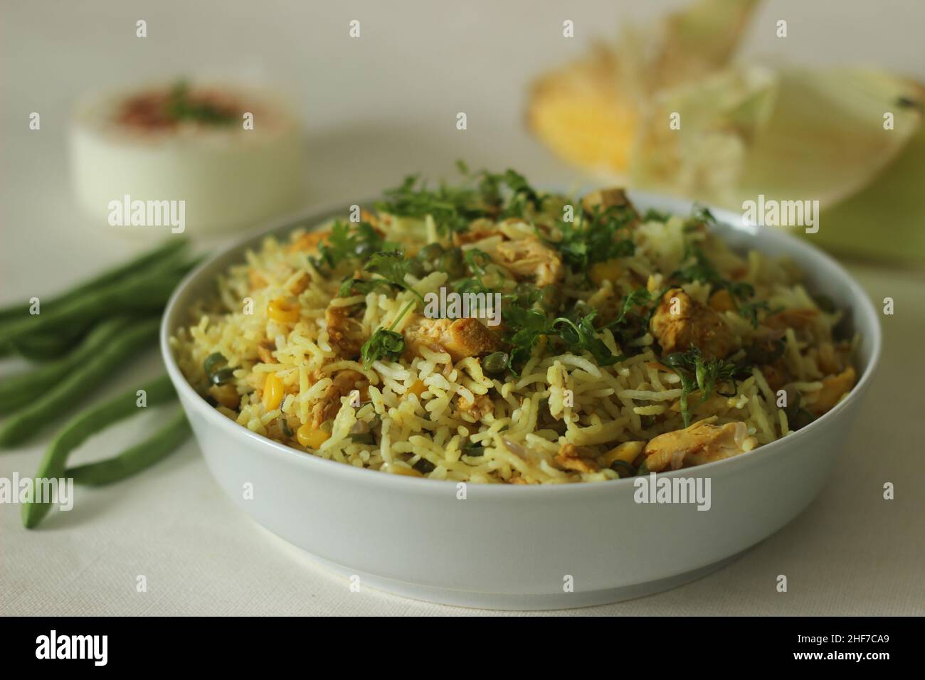 Sweetcorn chicken rice. Steamed basmati rice tossed with sauteed sweetcorn, beans and chicken. A rice dish for lunch or dinner. Shot with opened corn Stock Photo