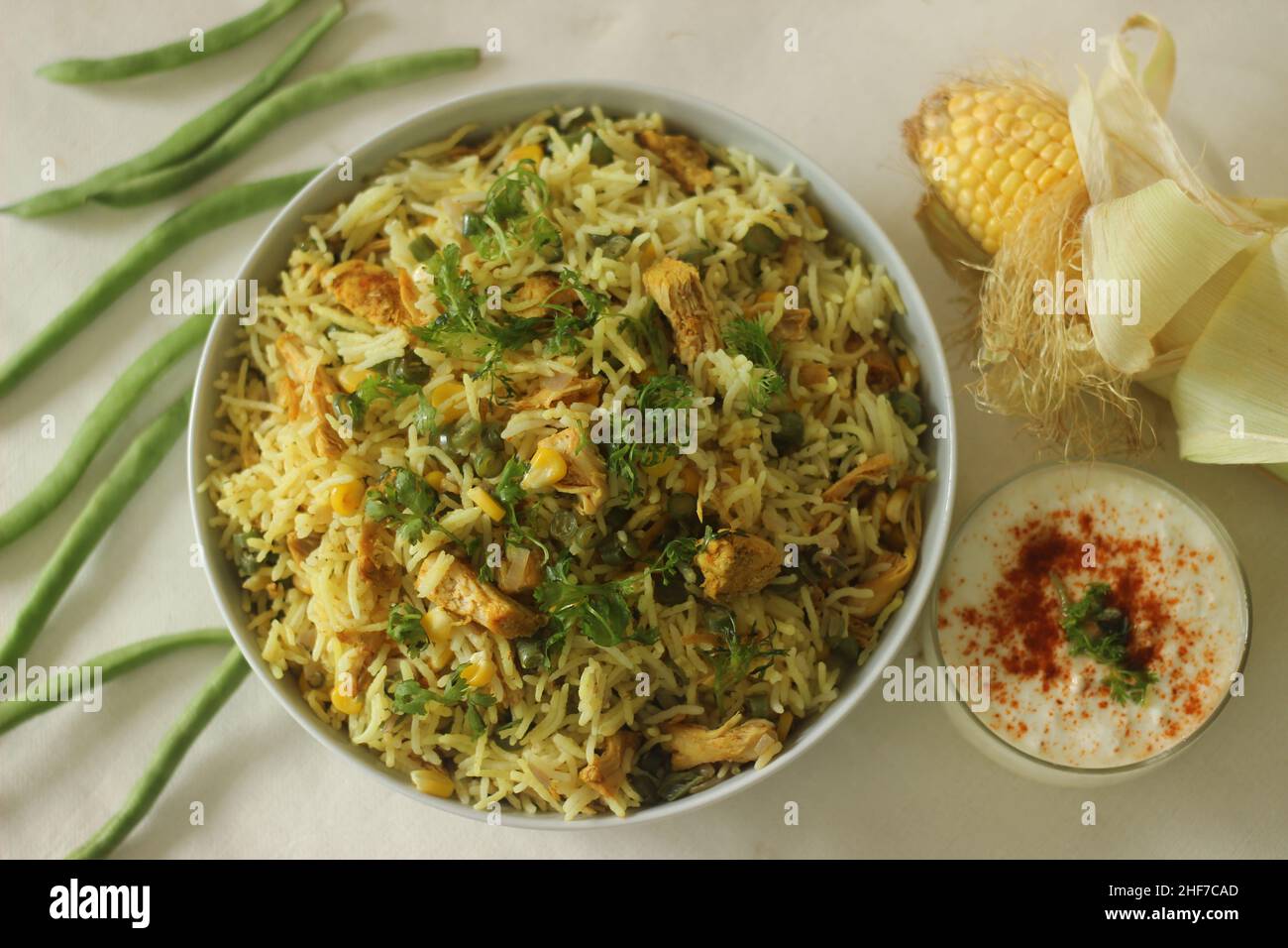 Sweetcorn chicken rice. Steamed basmati rice tossed with sauteed sweetcorn, beans and chicken. A rice dish for lunch or dinner. Shot with opened corn Stock Photo