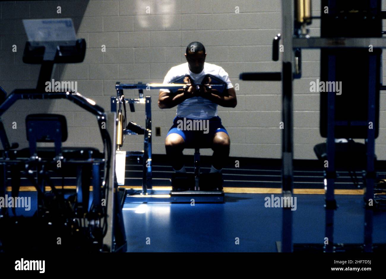 African American man doing workout in a gym on exercise equipment Stock Photo