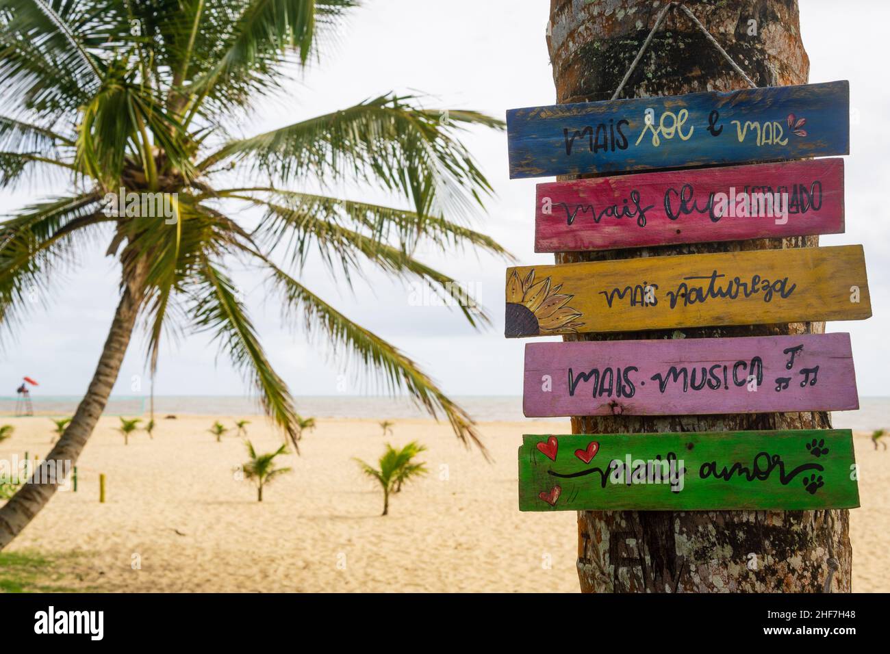 Hand painted wood signs saying mais sol e mar, mais céu estrelado, mais natureza, mais musica, mais amor at Guaratiba Beach, Prado, Bahia, Brazil. Stock Photo
