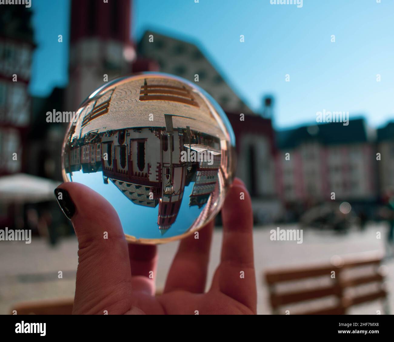 Old St Nicholas Church in Frankfurt's Romer Platz, Germany, through a crystal glass ball giving it a snow globe effect (upside down) Stock Photo