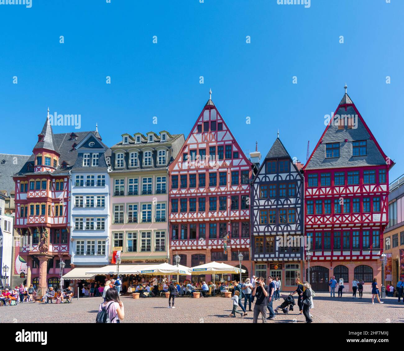Vibrant half timber houses in Romerplatz Frankfurt Germany with tourists enjoying the sunshine Stock Photo