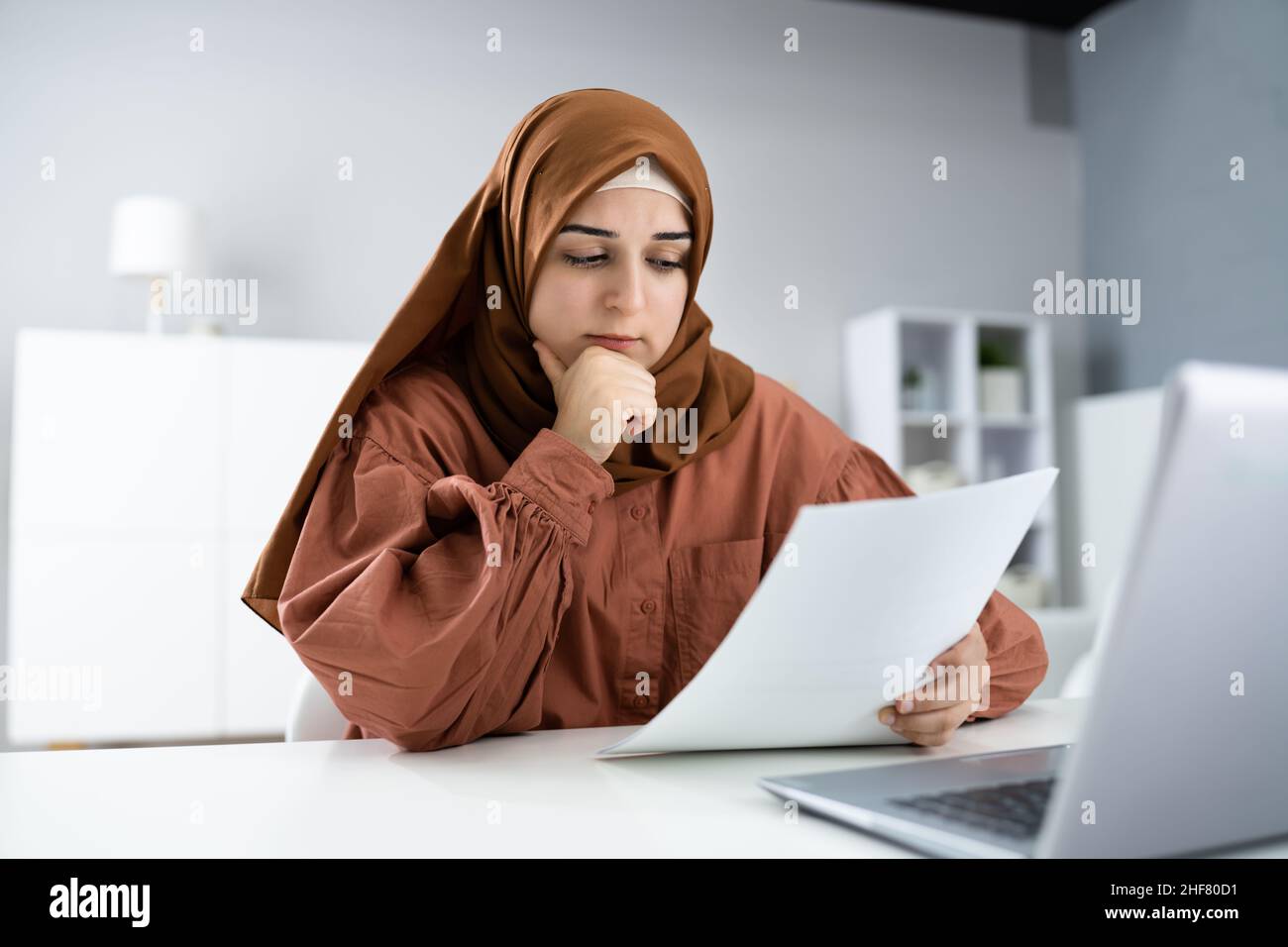Worried Muslim Woman Doing Taxes. Debt Stress Stock Photo