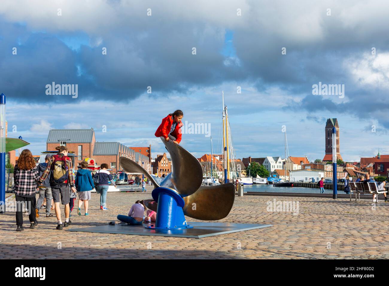Wismar,  Alter Hafen (Old Port),  historic sail ships,  view to Old Town,  children playing on ship propeller in Ostsee (Baltic Sea),  Mecklenburg-Vorpommern,  Germany Stock Photo