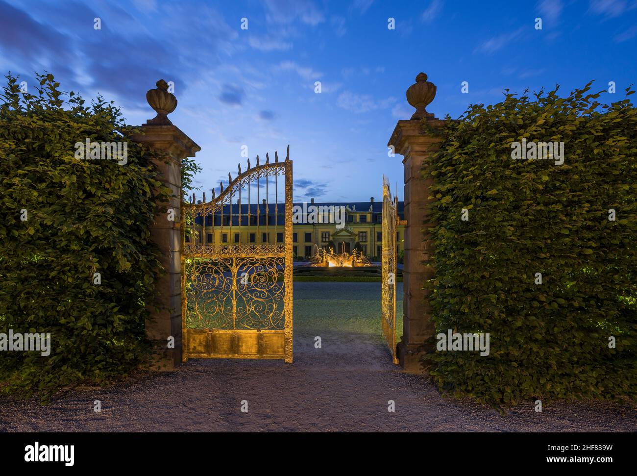Germany,  Lower Saxony,  Hanover,  gate and Neptune fountain in the orange parterre of the Herrenhausen Gardens in the evening,  in the background gallery Stock Photo