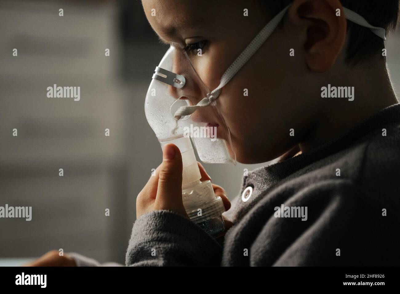 Home treatment. The boy makes inhalation with a nebulizer inhaling medicines into his lungs. Self-treatment of the respiratory tract with inhalation. Stock Photo