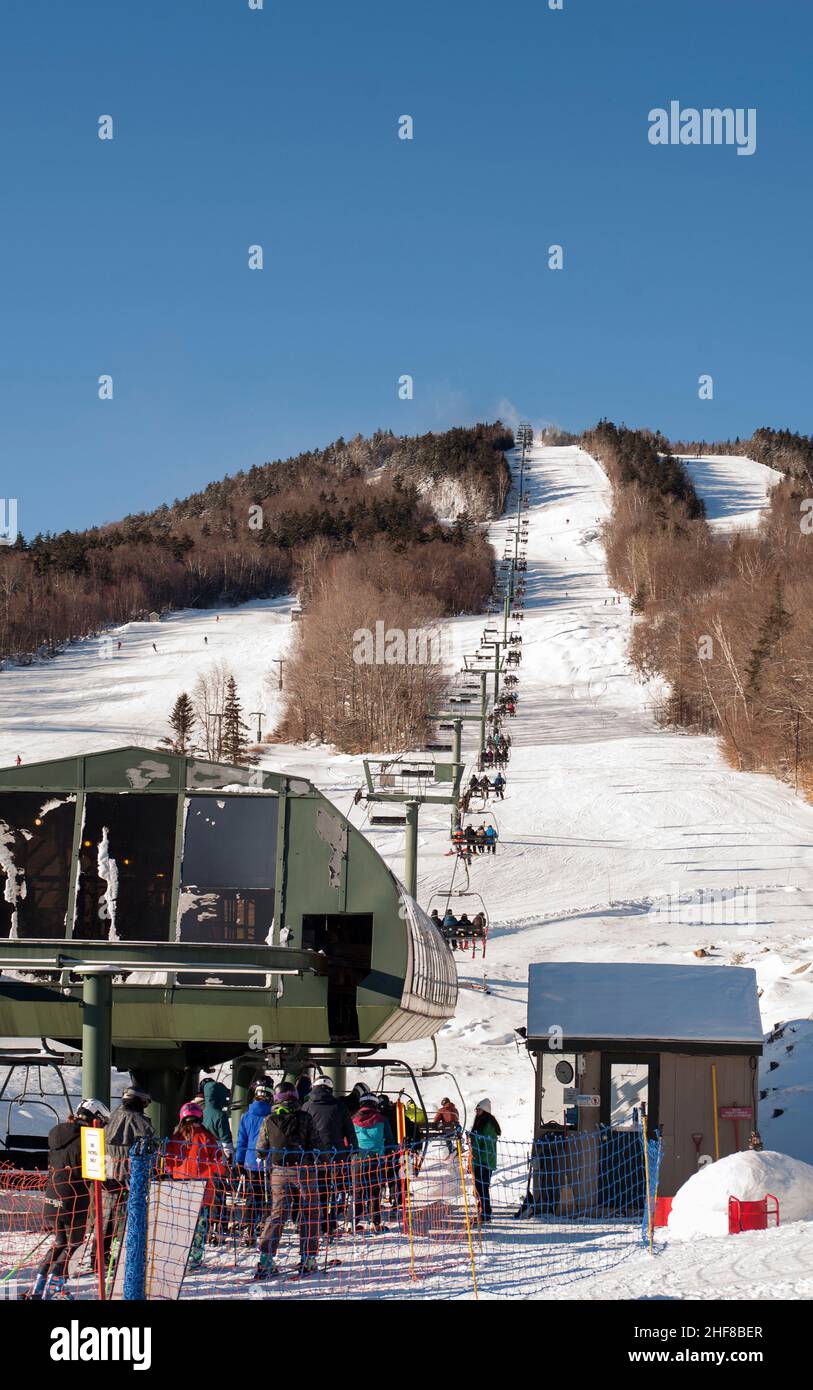 Skiers line up at the White Peaks Quad chairlift at the Waterville Valley ski resort in Waterville Valley, New Hampshire, USA. Stock Photo
