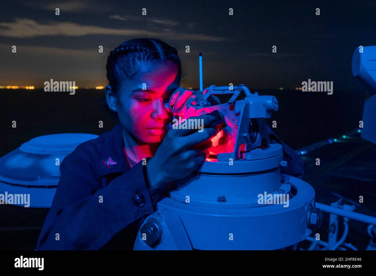 Jan 11, 2022 - STRAIT OF MALACCA - Quartermaster 3rd Class Orpha Hapdei, from Yap, Micronesia, uses a telescopic alidade aboard the amphibious assault ship USS Essex (LHD 2) during strait transit operations, Jan. 11, 2022. Essex, flagship of the Essex Amphibious Ready Group (ARG), along with the 11th Marine Expeditionary Unit (MEU), is operating in the U.S. 7th Fleet area of operations to enhance interoperability with alliances and partners and serve as a ready response force to ensure maritime security and a free and open Indo-Pacific region. (Credit Image: © Brett McMinoway/U.S. Navy/ZUMA Pr Stock Photo