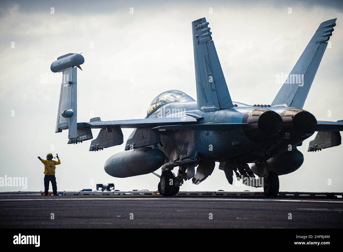 At Sea. 14th Jan, 2022. A Sailor directs an EA-18G Growler, assigned to the Gauntlets of Electronic Attack Squadron (VAQ) 136, on the flight deck of Nimitz-class aircraft carrier USS Carl Vinson (CVN 70), Jan. 14, 2022. Carl Vinson Carrier Strike Group is on a scheduled deployment in the U.S. 7th Fleet area of operations to enhance interoperability through alliances and partnerships while serving as a ready-response force in support of a free and open Indo-Pacific region. Credit: Leon Vonguyen/U.S. Navy/ZUMA Press Wire Service/ZUMAPRESS.com/Alamy Live News Stock Photo