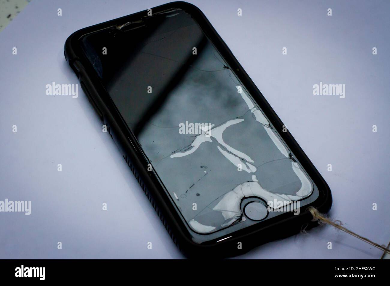 Broken phone screen with glass protector and string attached Stock Photo