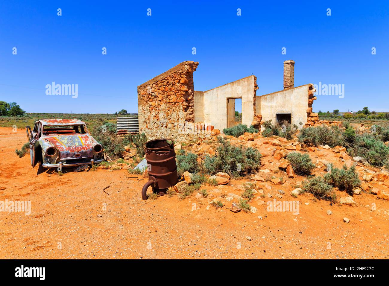 Car wreckage and old ruined stone house in abandoned ghost town SIlverton near Broken Hill of Australia. Stock Photo