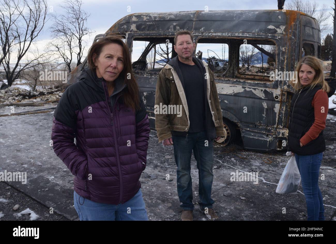 Fire victims Cheryl & Nathan Ruff, & neighbor Lisa Laguardia, in front of burned-out van in the Ruff's former garage. Laguardia also lost her home. Stock Photo