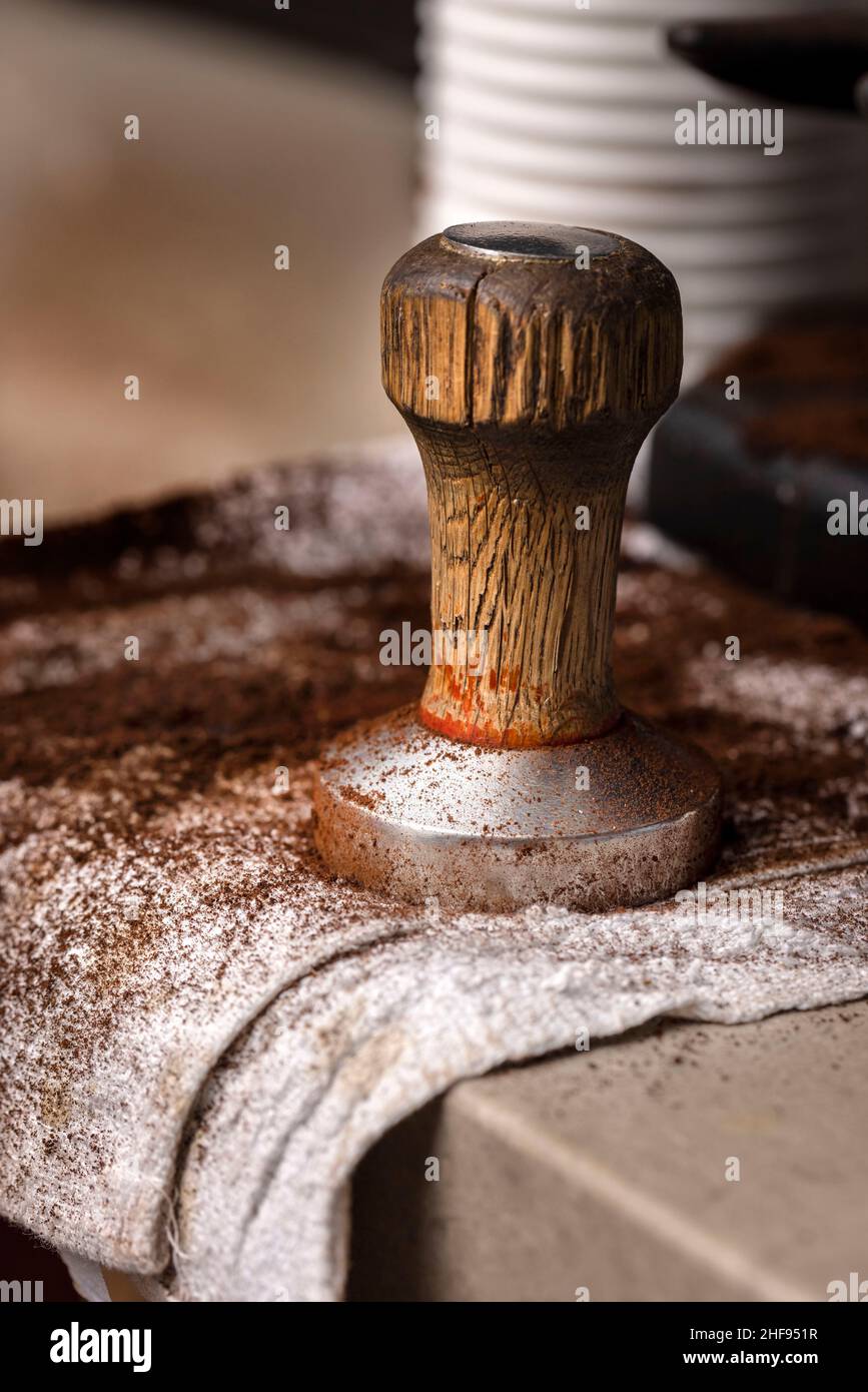Wood and metal coffee tamp on a towel with coffee grounds Stock Photo