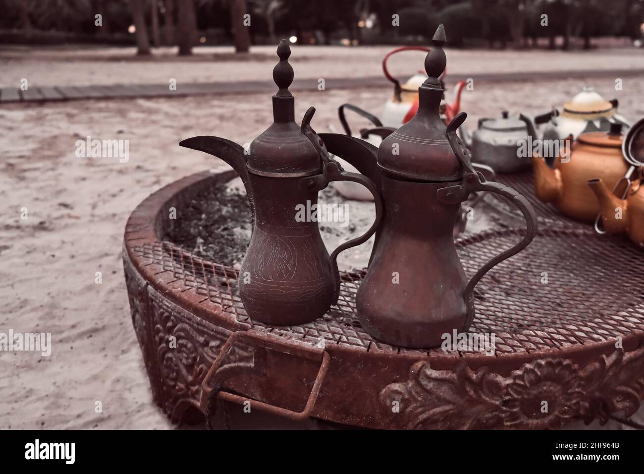 Traditional vintage arabic coffee pots at bedouin fireplace in the desert.Coffee jugs in Bedouin tent in the middle east. Stock Photo