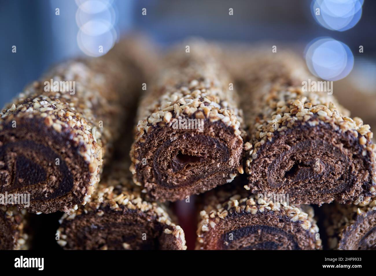 chocolate sponge cake rolls with cream and crispy almonds Stock Photo