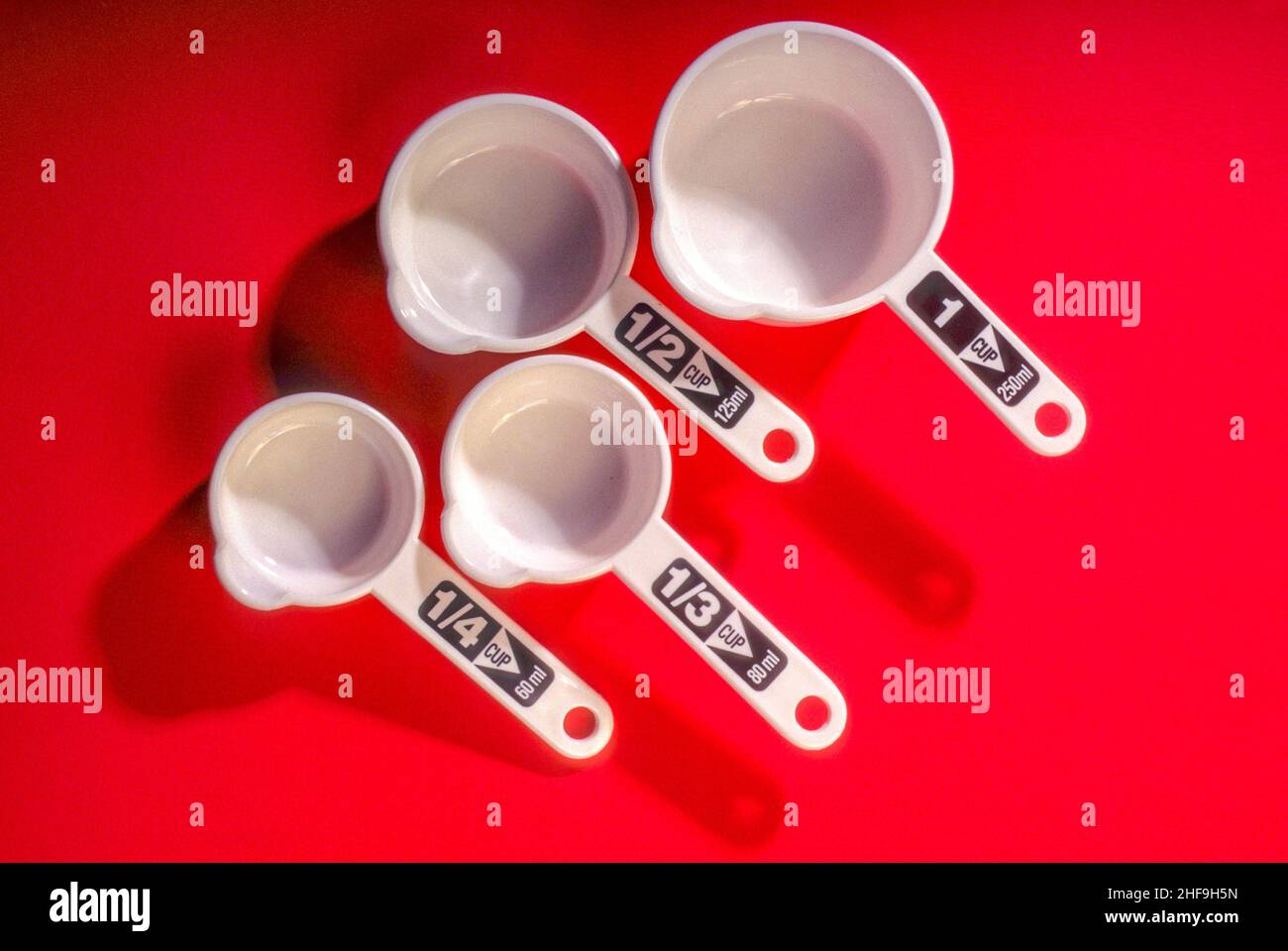 Four liquid measuring cups with labels indicating their capacity are