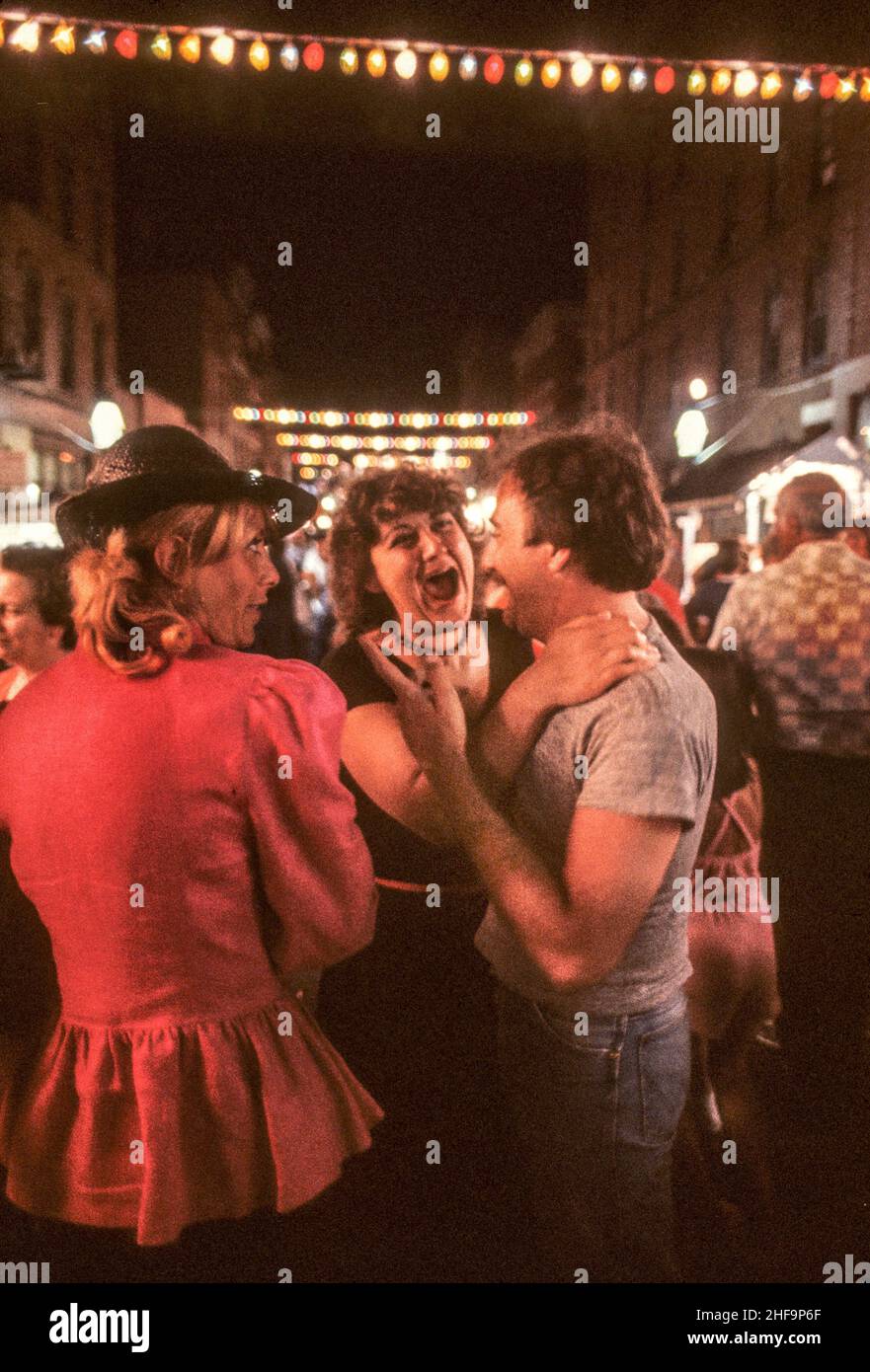 An affectionate couple enjoy a night time festival of a Catholic saint in the North End neighborhood of Boston, MA. Stock Photo