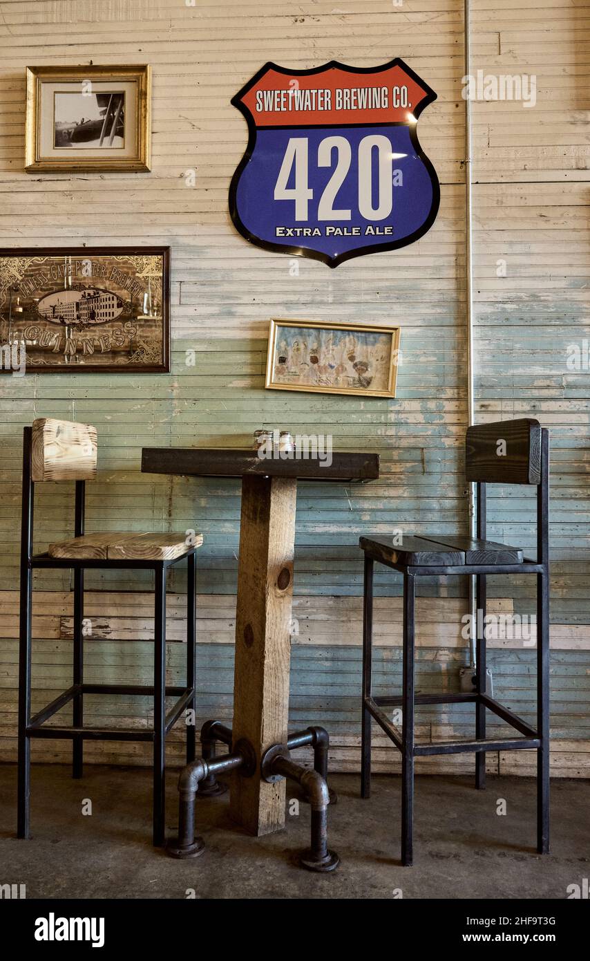 Restaurant high top table for two and vintage decor in the quaint small town Pizza and Pints restaurant in Sylacauga Alabama, USA. Stock Photo