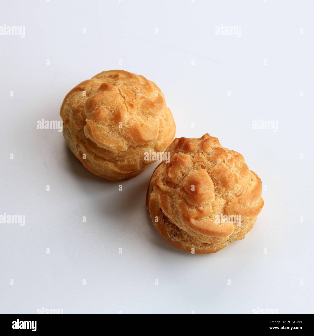 Two Choux Cream on White Background. Profiterole, Eclair, Cream puff. Isolated Stock Photo