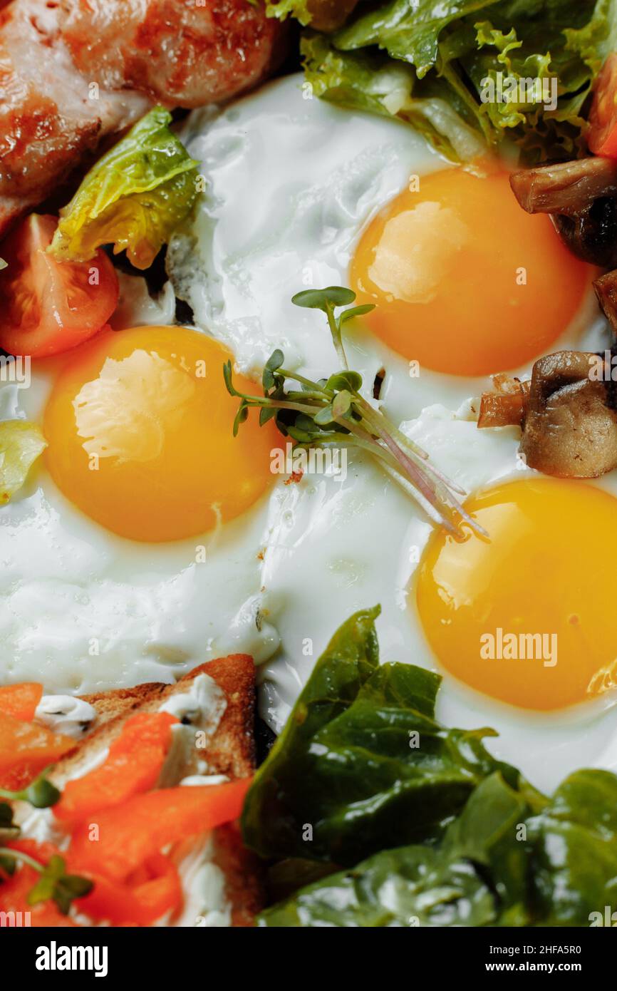 Full English breakfast with toast bread, chicken egg, mustard sauce, champignons, salad mix