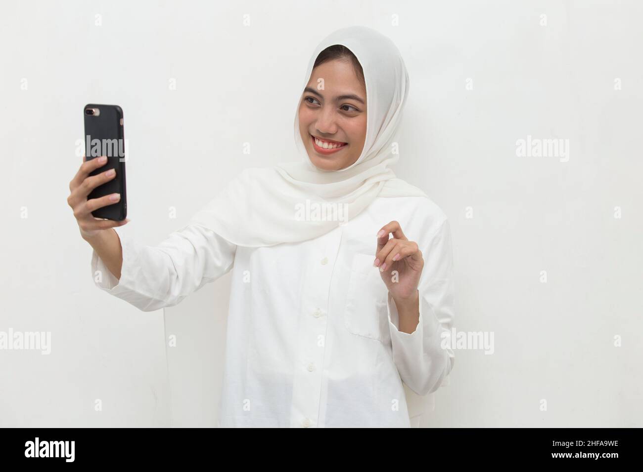happy young asian muslim woman using mobile phone Stock Photo - Alamy