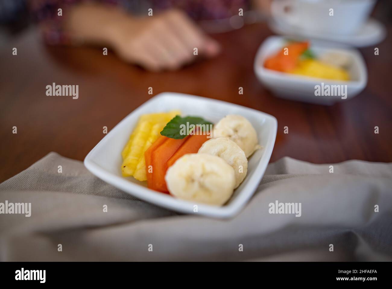 Square plates with fresh fruit slices on brown table Stock Photo