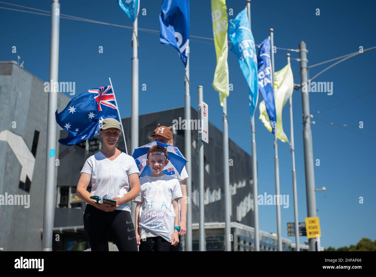Melbourne, Australia. 15th Jan, 2022. 15th January 2022, Melbourne, Australia. A mother and her children pose for a photo in front of Australian Open flags outside Flinders Street Station as part of an anti-vax protest. Credit: Jay Kogler/Alamy Live News Credit: Jay Kogler/Alamy Live News Stock Photo