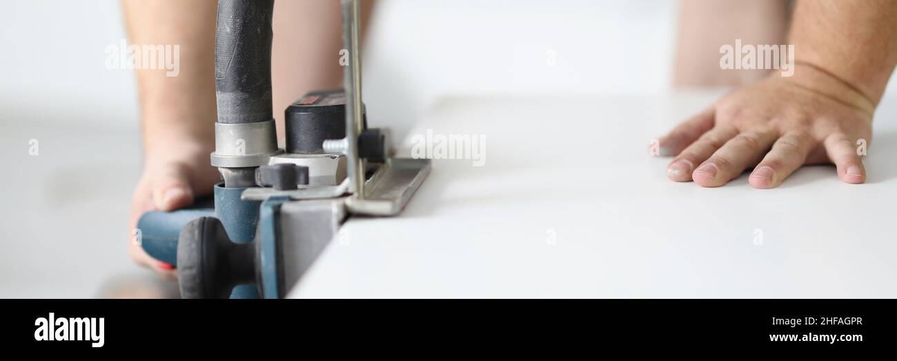 Male hands working with an electric plane close-up Stock Photo