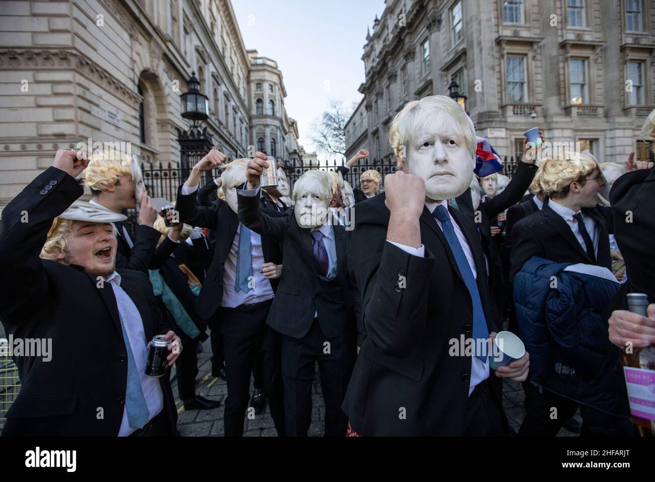 London, UK. 14 January 2022. Flash-mob of 'partygate' anti-Boris Johnson protesters wearing floppy blond wigs and Boris Johnson masks and suits gathered outside Downing Street drinking beer and wine while dancing to techno music and chanting 'This is a work event!' after the UK Prime Minister is under investigation for holding a drinks party at No.10 Downing Street on various occassions breaking the COVID lockdown restrictions during the pandemic.Friday 14th January 2022. Whitehall, London, England, United Kingdom Credit: Jeff Gilbert/Alamy Live News Stock Photo