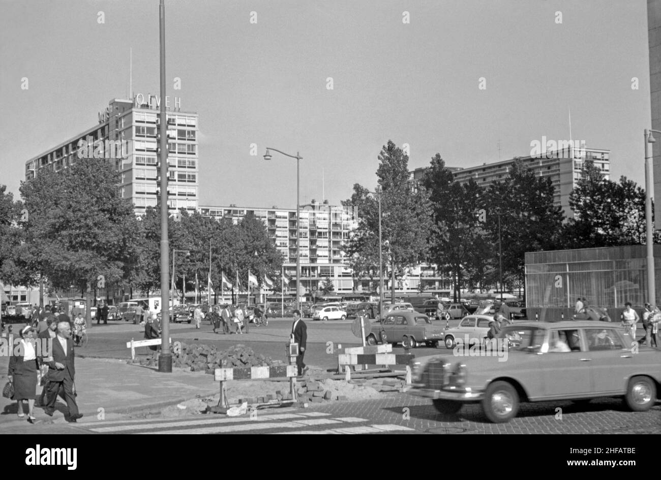 A view across Schouwburgplein of the apartment blocks along Karel Doormanstraat, the (de) Lijnbaan, Rotterdam, the Netherlands in the 1960s. The layout of the residential development, which opened in the late 1950s, separated shops from apartments and were arranged around green courtyards. It was designed by the firm Van den Broek & Bakema led by architects Jo van den Broek and Jacob B (Jaap) Bakema. Today this area completely pedestrianised – a vintage 1960s photograph. Stock Photo