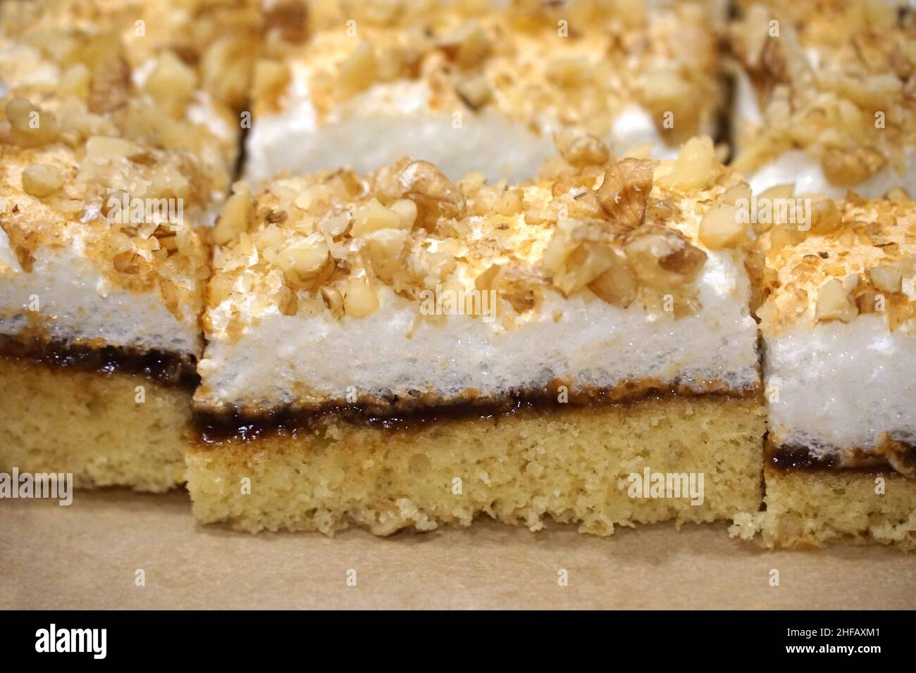 Layered fluffy biscuit cake with egg white snow and chopped nuts Stock